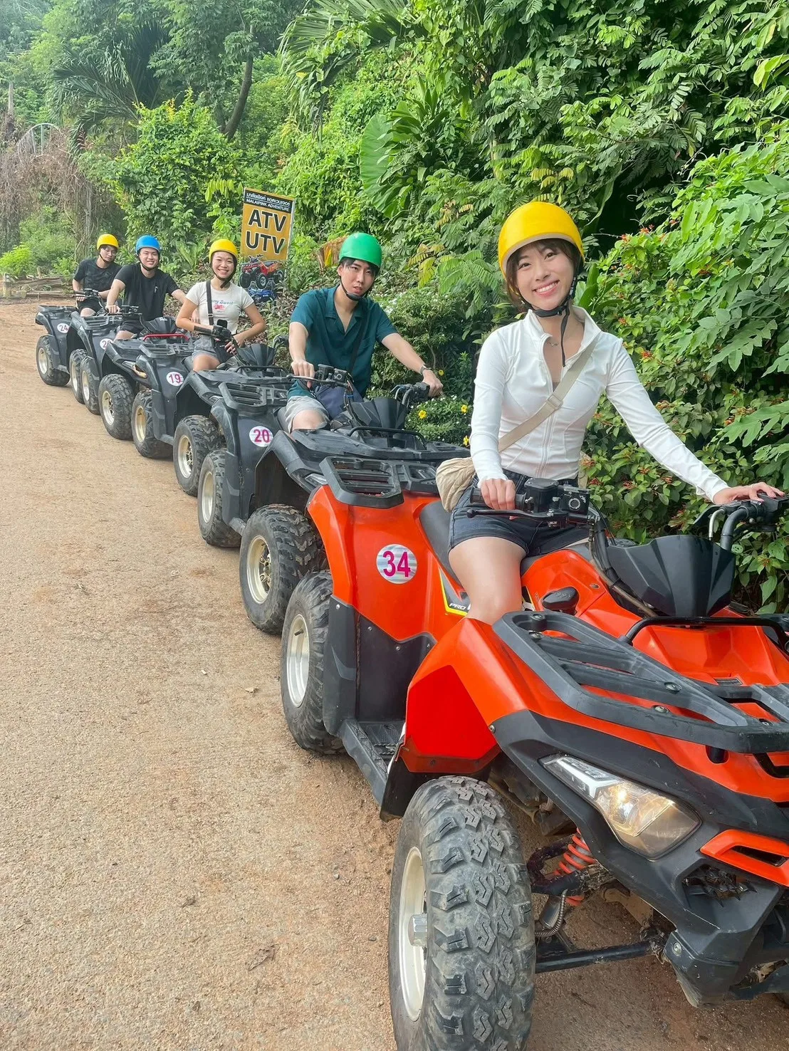กลุ่มนักท่องเที่ยวขับ ATV เรียงแถวบนเส้นทางดินกลางป่าเขียวชอุ่ม